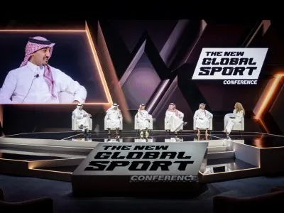 Saudi industry leader speaking during panel at The New Global Sport Conference 2025, with fellow panelists seated under event branding
