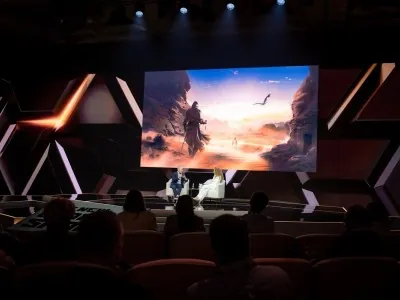 Audience watching cinematic esports showcase on screen at NGSC 2025 conference stage