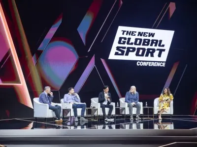 Diverse speaker panel at The New Global Sport Conference 2025 under branded stage lights