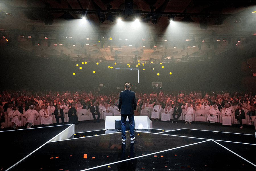 Keynote speaker on stage at NGSC 2025 in Riyadh with a full audience, spotlighting the future of gaming, esports, and sports